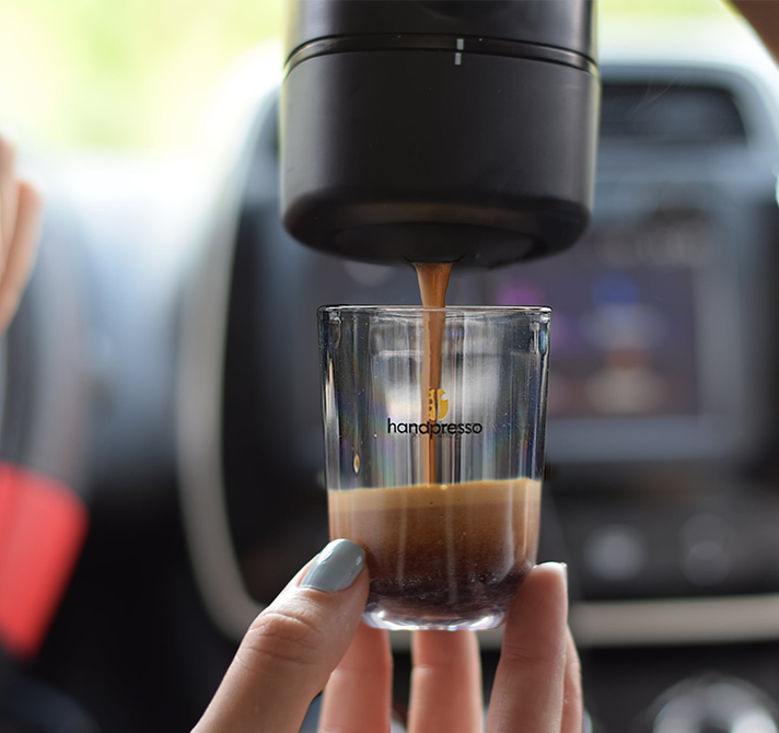 Handpresso připravuje espresso do skleničky uvnitř auta